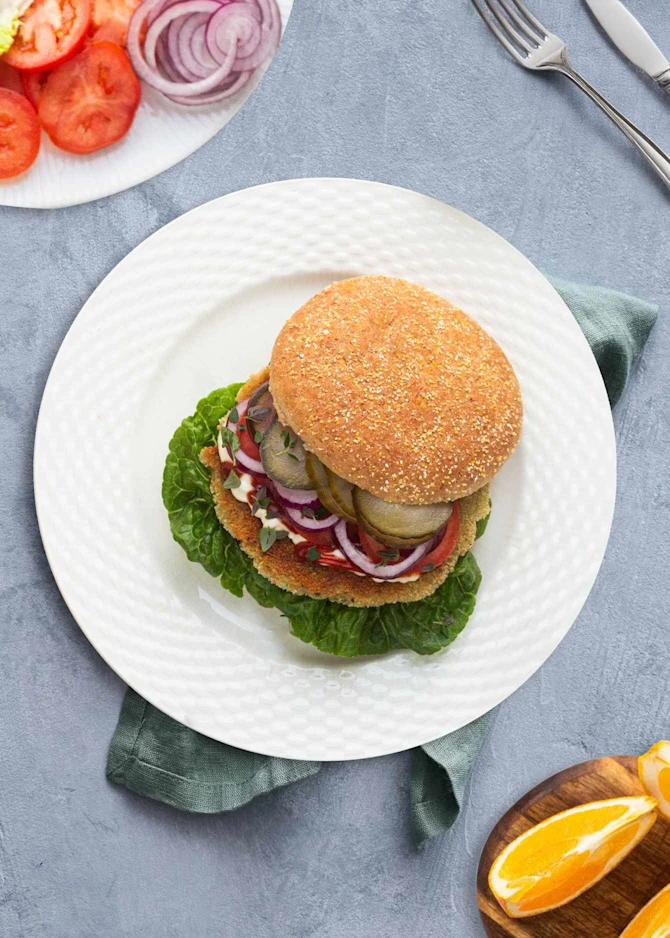 Vegetarburger med paneret squashbøf og grøntsager. Hertil appelsinbåde
