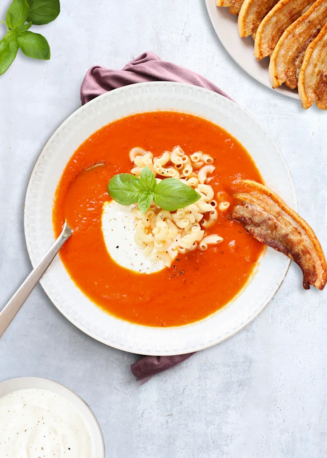 Tomatsuppe serveret med stegt flæsk og suppehorn
