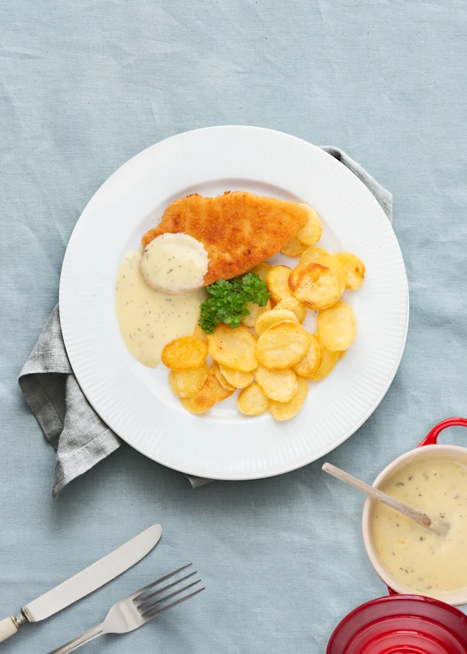 Panerede schnitzler med sprøde kartoffelskiver, sennepssauce og salat