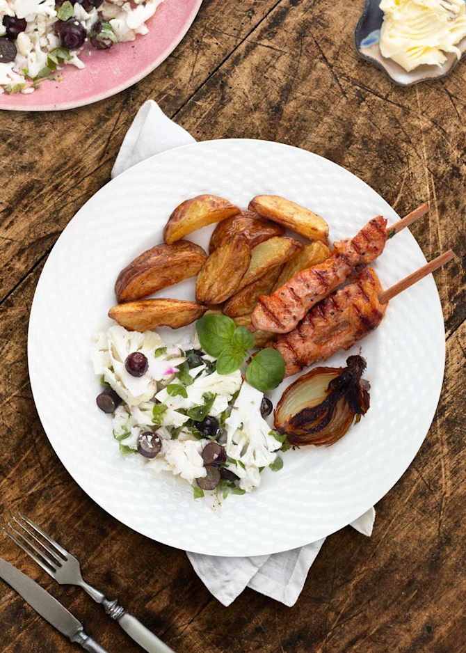 Kyllingespyd serveret med ovnkartofler, hvidløgssmør og salat