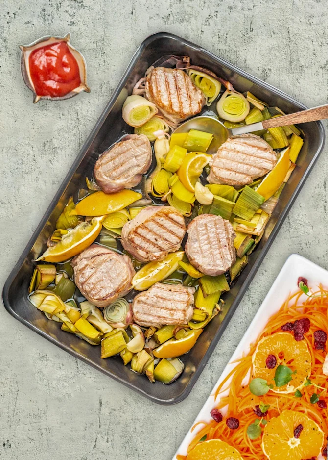 Saftige bøffer af marineret filet serveret med fritter og appelsinsalat