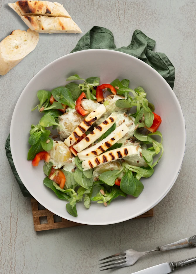 Kartoffelsalat vendt i avocadocreme og grillost. Hertil hvidløgsflutes
