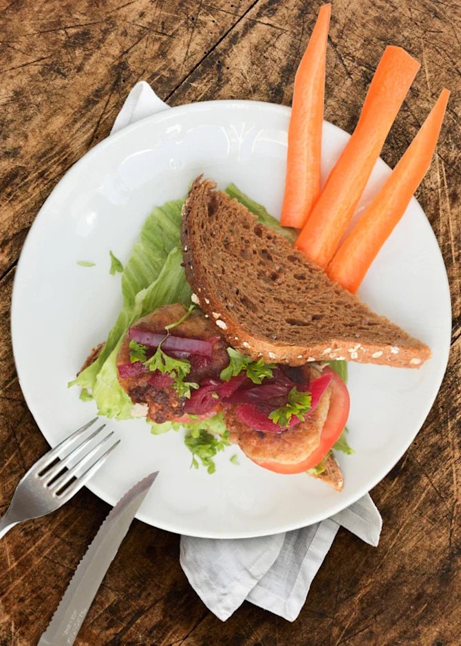 Frikadellesandwich med syltede rødløg. Hertil gulerødder