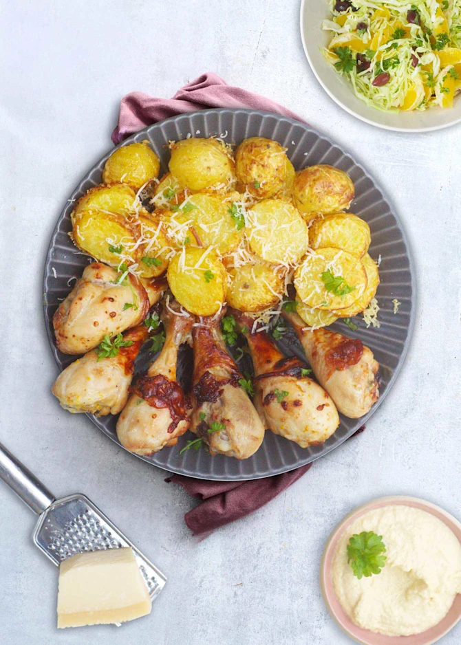 Kyllingelår serveret med parmesan-kartofler, salat og hummus