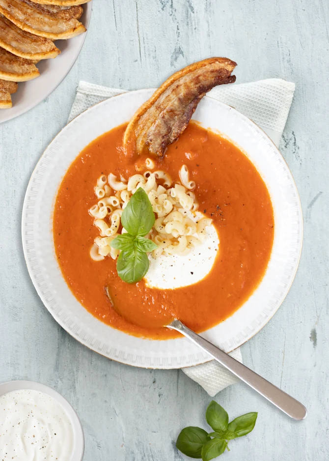Tomatsuppe serveret med stegt flæsk og suppehorn
