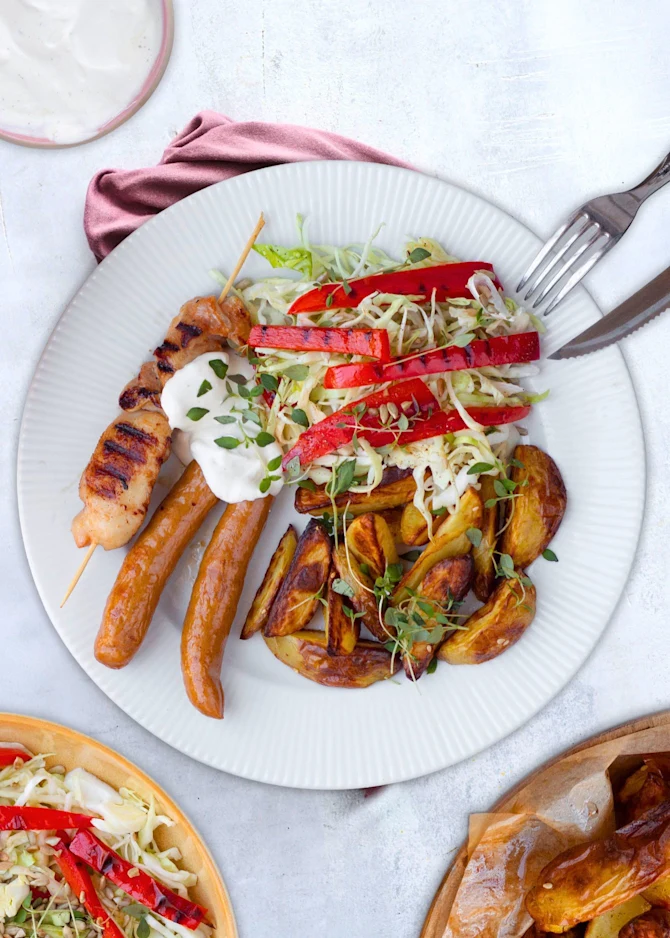 Mixed grill med kyllingespyd, pølser og grillet salat. Hertil ovnkartofler