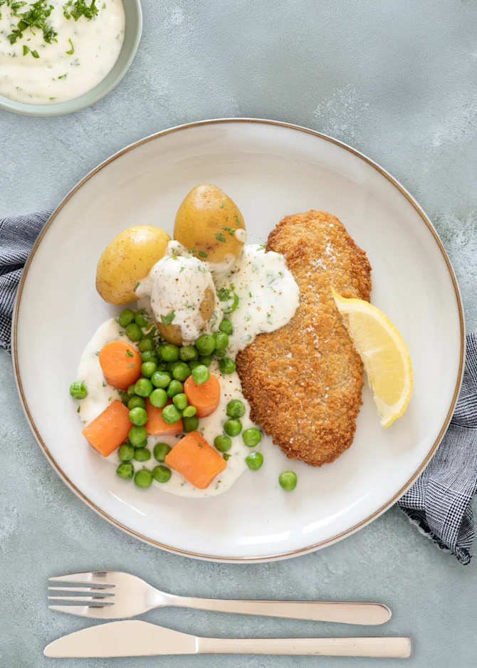 Fiskefilet med kartofler, gulerødder og ærter. Hertil persillesovs