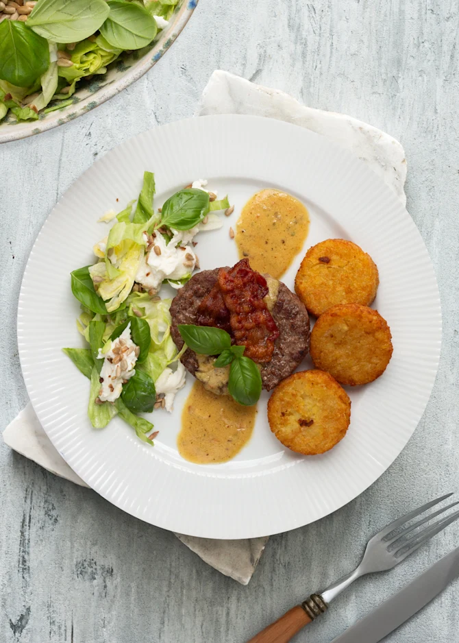 Hakkebøffer med bacon, pandesauce, kartoffelrøsti og grøn salat