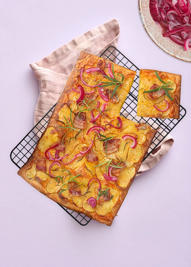Hvid pizza med kartofler, bacon og syltede rødløg. Hertil appelsinskiver
