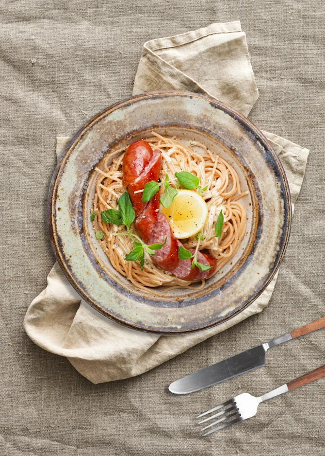 Spaghetti serveret med citronsauce og kålpølser. Hertil grønt