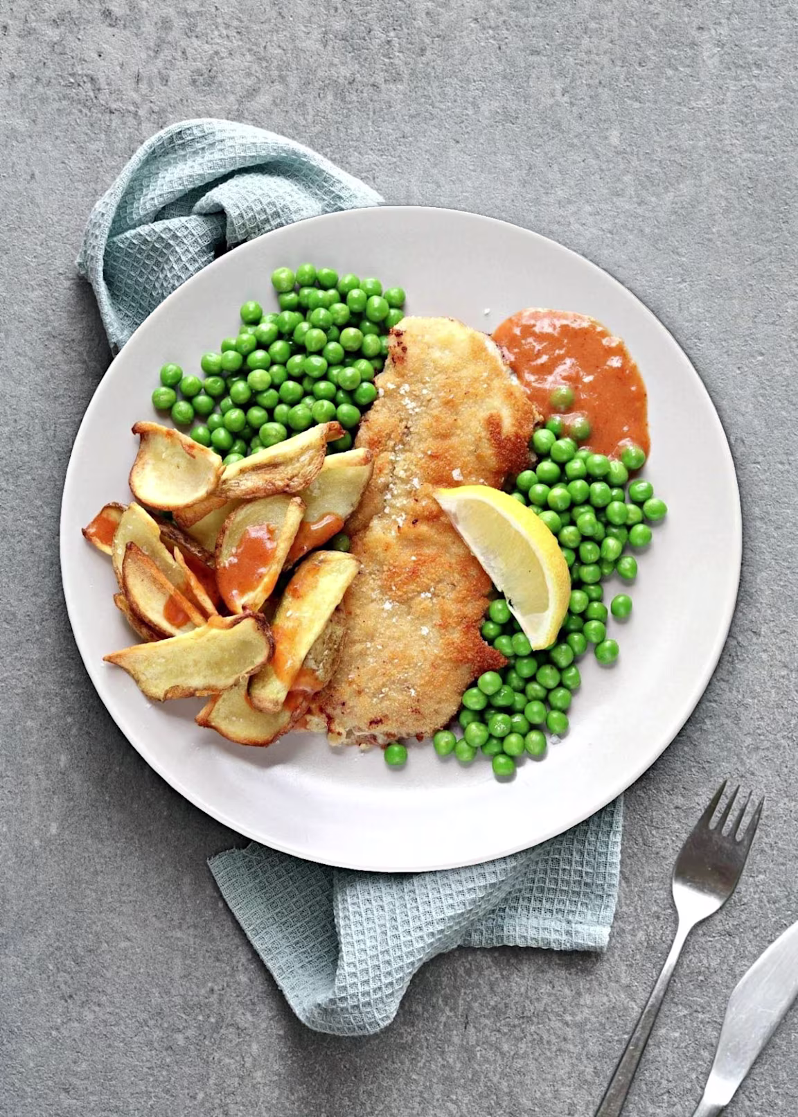 Paneret skinkeschnitzel med fritter, ærter og favoritsauce