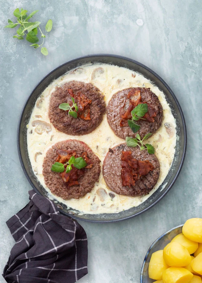 Hakkebøffer med bacon i svampesauce. Hertil kartofler og salat