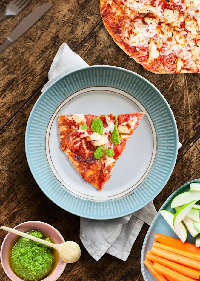 Pizza med kylling, tomat og pesto. Hertil gulerødder og pærer.