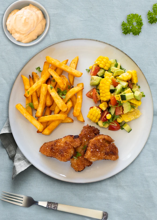 Pankopanerede schnitzel-bites med fritter og majssalat med avocado
