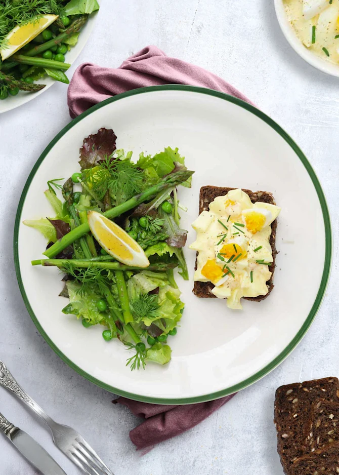 Æggesalat på sprødristet rugbrød. Hertil aspargessalat
