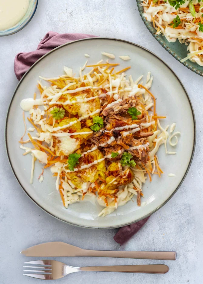 Pulled chicken med knuste kartofler, revet ost og coleslaw