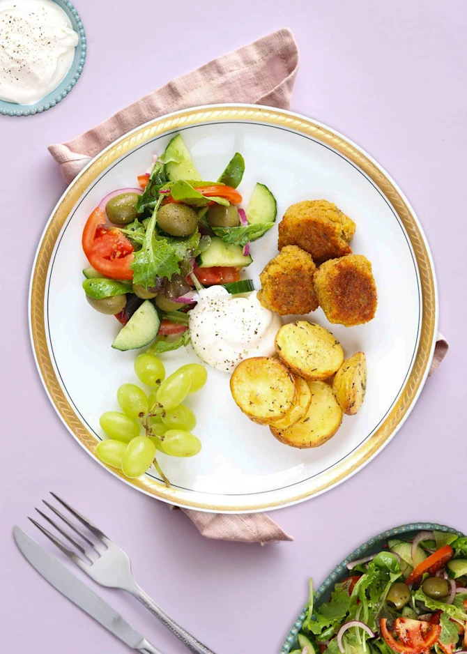 Sprøde falafler, ovnkartofler og salat med oliven. Hertil hvidløgsdressing og vindruer
