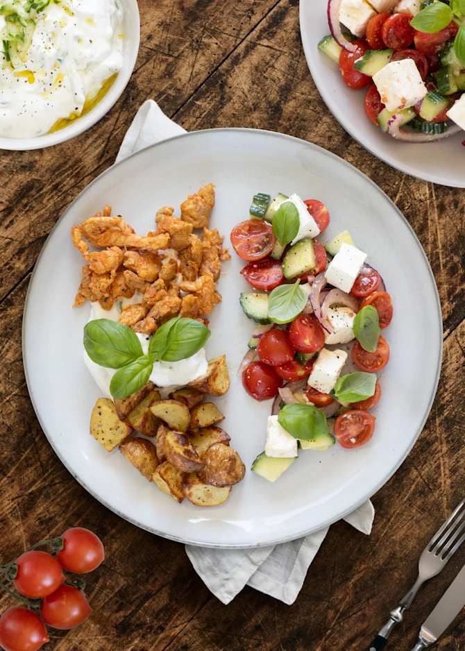 Gyros serveret med tomatsalat, kartoffeltern og tzatziki