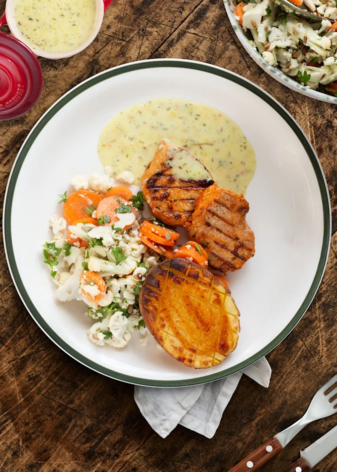 Stegt svinefilet serveret med bagte kartofler, sauce og salat